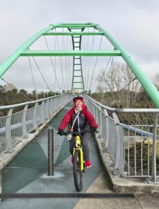 Woman on an e-bike, cycling across a bridge over the Waikato River