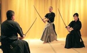 Three people dressed as samurai warriors with swords